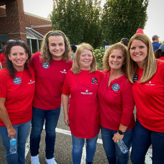 image of current and a past employee helping at community days